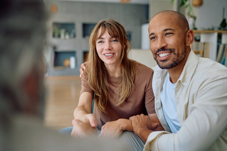 Young couple smiling and shaking hands with a consultant